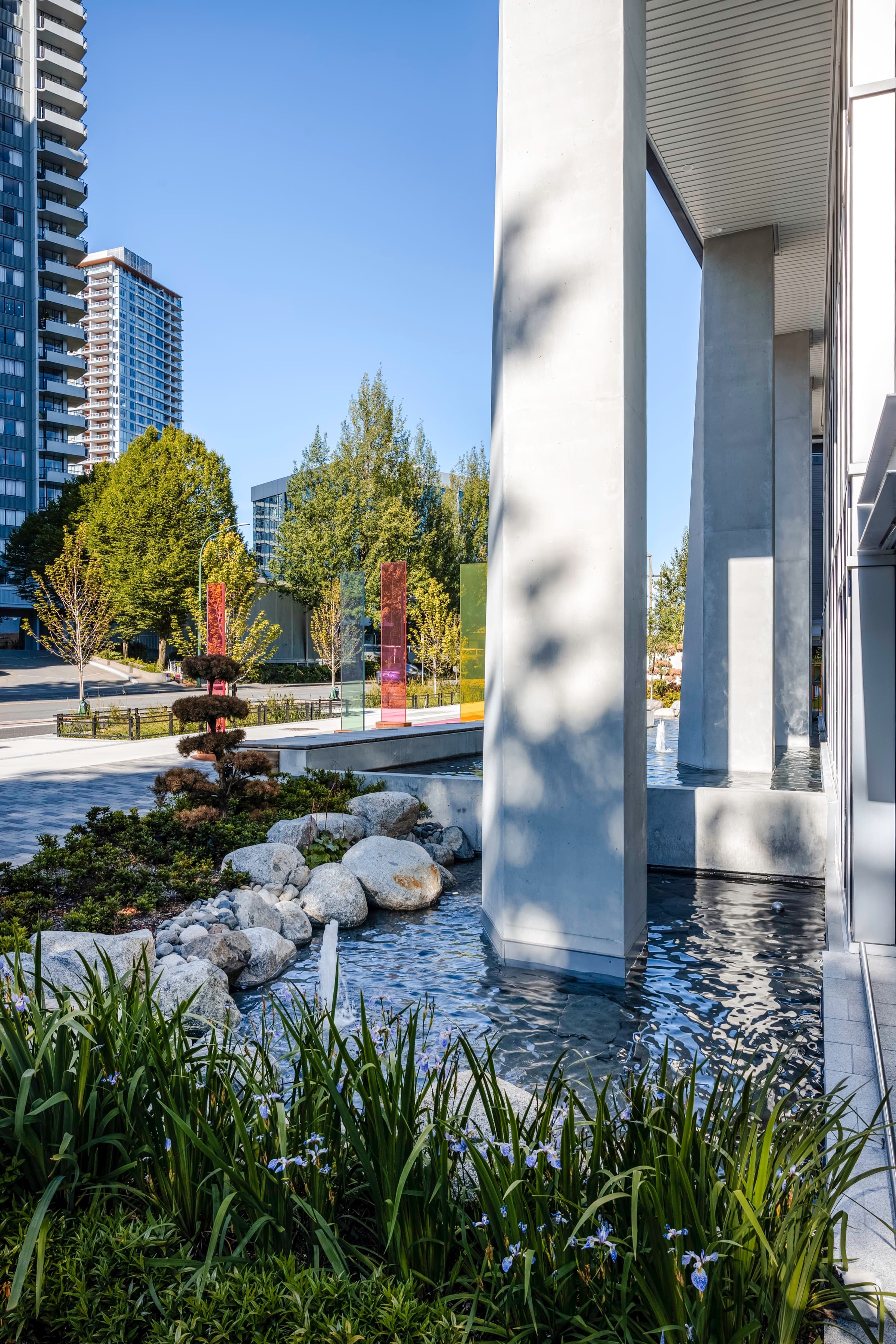 The Artesia lobby colonnade rising from its reflecting pool, with irises and river stones in the foreground